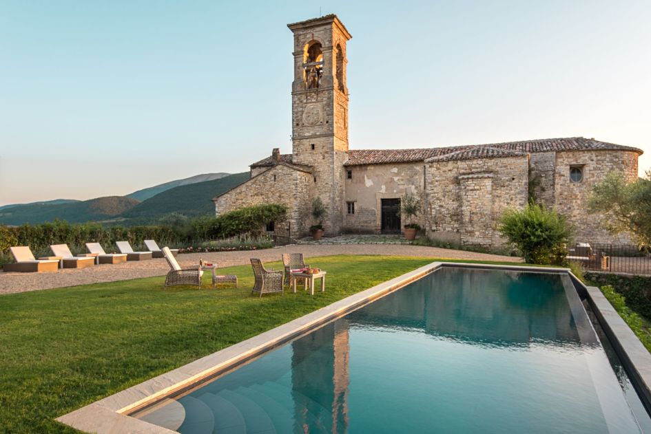 Villa Castiglione Ugolino pictured with the outdoor pool and rolling Umbrian countryside in the background 