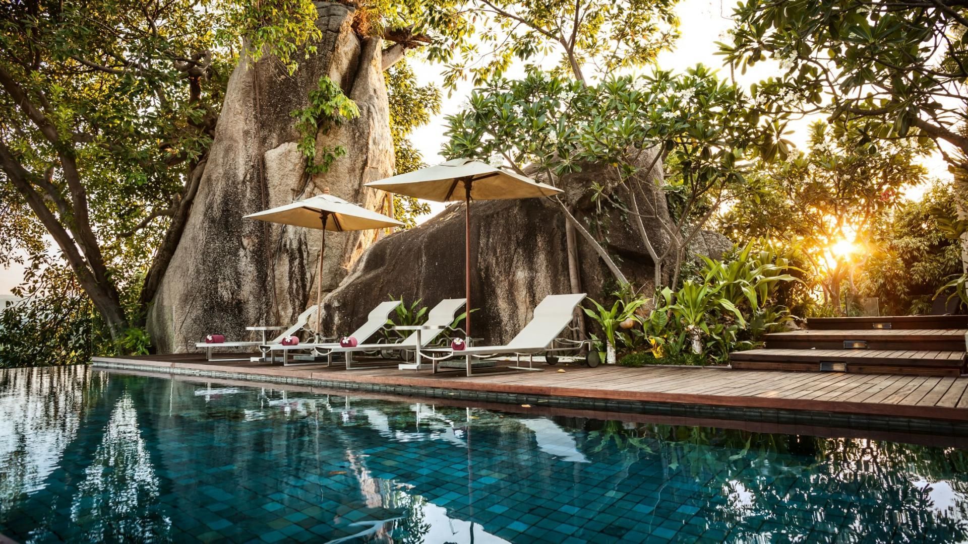 Sunset, deckchairs, and a luxury swimming pool at a stunning luxury villa in Koh Samui, surrounded by nature. A great place for a Koh Samui proposal.