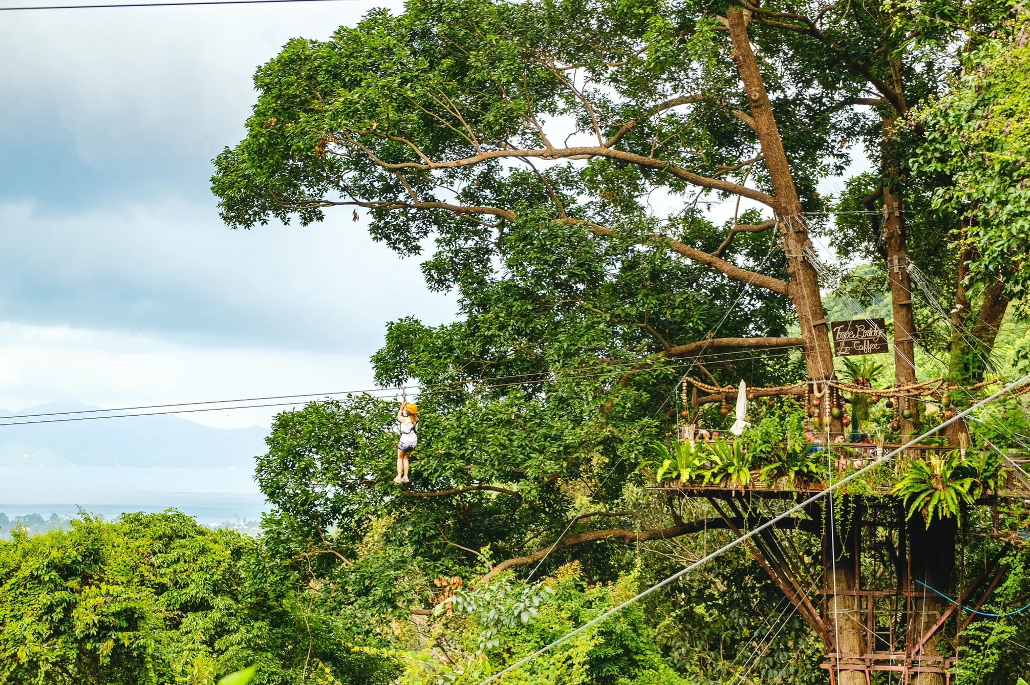 A person leaving a zipline station on a treetop zipline in Koh Samui. One of the most adventurous places to propose in Thailand.