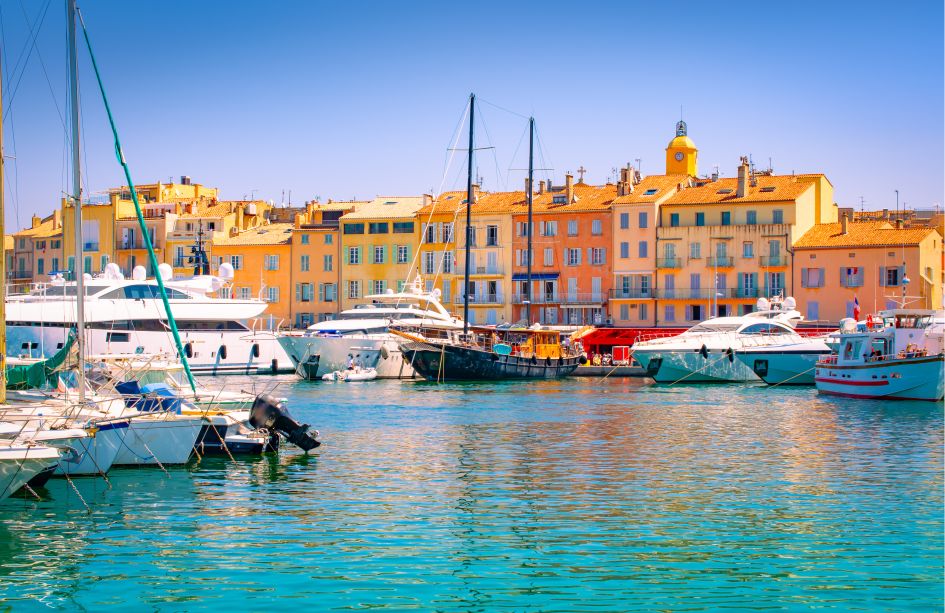 Yachts in St Tropez marina with typical buildings in the background.