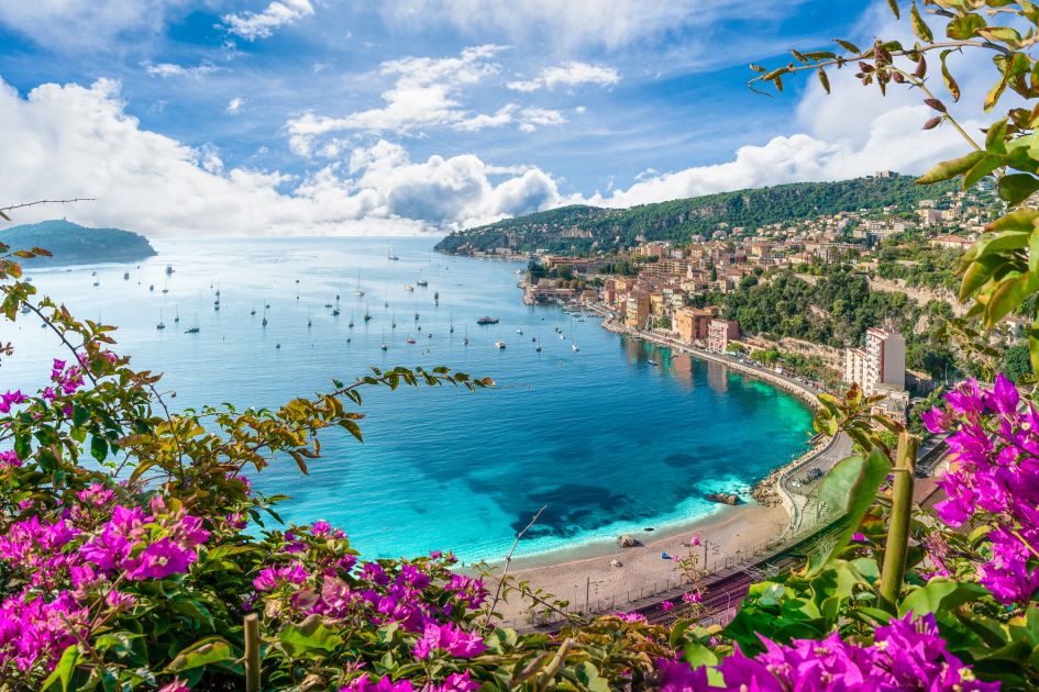 French Riviera coastline with crystal clear waters and boats in the background