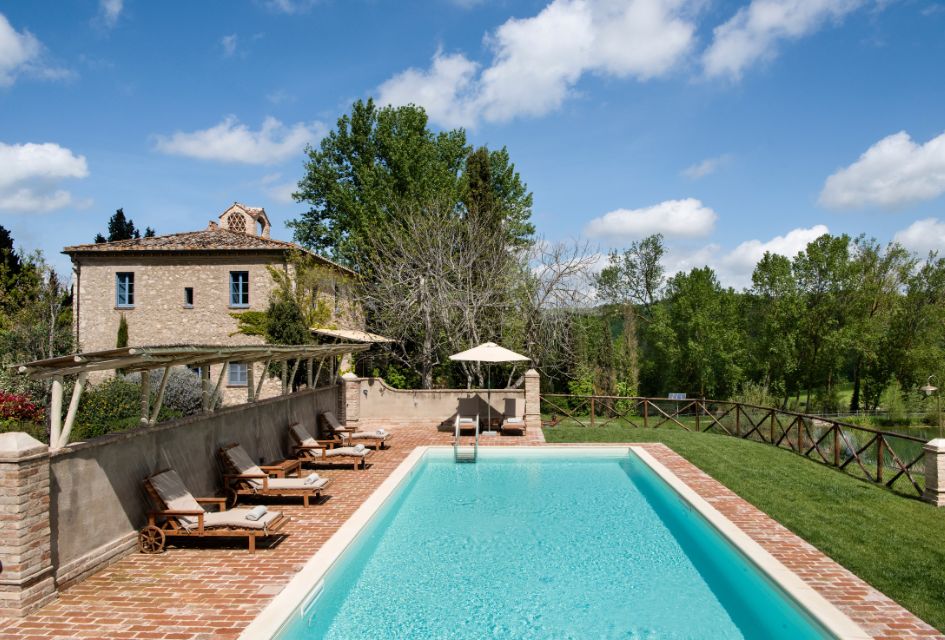 Villa La Fonte, Tuscany The swimming pool and exterior of Villa La Fonte, with the lake to the right and sun loungers on the left.