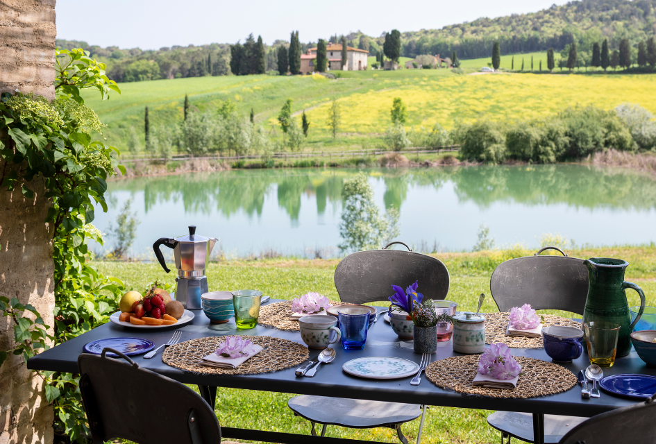 Dining setting at Borgo Pignano Dining with a view of the lake and Tuscan hills upon the luxury villa estate, Borgo Pignano