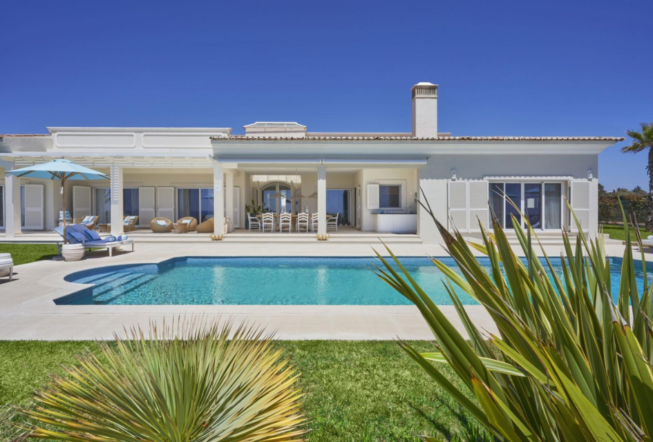 Villa Hibiscus Beach House, Algarve From behind the garden greenery, a view of the exteriors of Villa Hibiscus Beach House and the outdoor pool., a great option to live in luxury when holidaying in the Algarve.