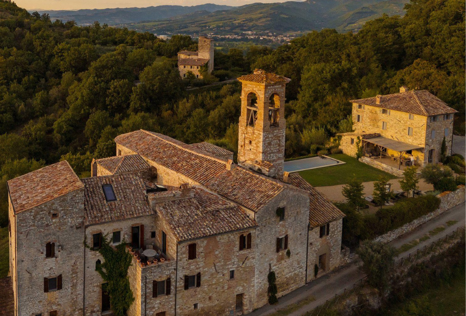 Villa Castiglione Ugolino, Umbria, Italy The beautiful Villa Castiglione Ugolino in Umbria at sundown, with late afternoon light bounding off the towers of the ancient building, and the swimming pool and annexe visible. High in the hills of Umbria.