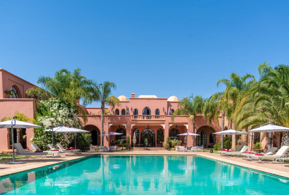 Palais Hassoun, Marrakech, Morocco Exterior view from the pool of the pinkish coral Palais Hassoun, a top unique luxury villa in Marrakech.