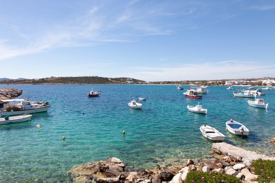Picture of fishing boats taken from the shores of Aliki Bay in Paros, with beautiful calming waters and clear skies.