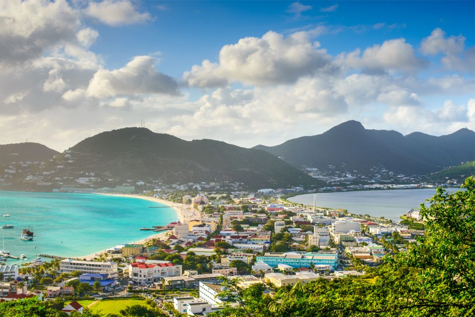 Philipsburg, Saint Martin © SeanPavonePhoto via Canva.com Views of Philipsburg in Saint Martin, showcasing the town's buildings between two stretches of beautiful blue water and the mountains in the background - perfect for a Caribbean holiday!