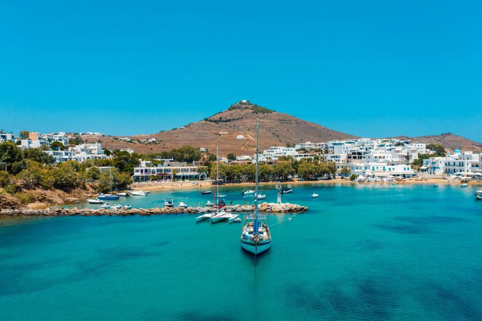 Piso Livadi is a charming fishing village in eastern Paros, showcasing beautiful clear seas and skies, and a collection of boats and buildings that line the waterfront.
