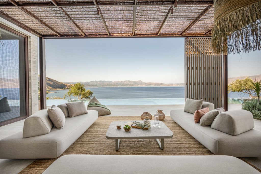 Bliss House Villa, Crete Outdoor living area of one of Greece's most impressive luxury villa rentals. Three sofas around a coffee table and sea views beyond