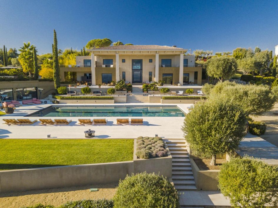 It's not just the service that's sure to impress at one of France's ultimate luxury catered villas! The majestic facade and swimming pool terrace seen at Domaine de L'Ansa in Cannes, showcasing vibrant blue skies and verdant green gardens that depict a typical luxury catered villa holiday on the French Riviera.