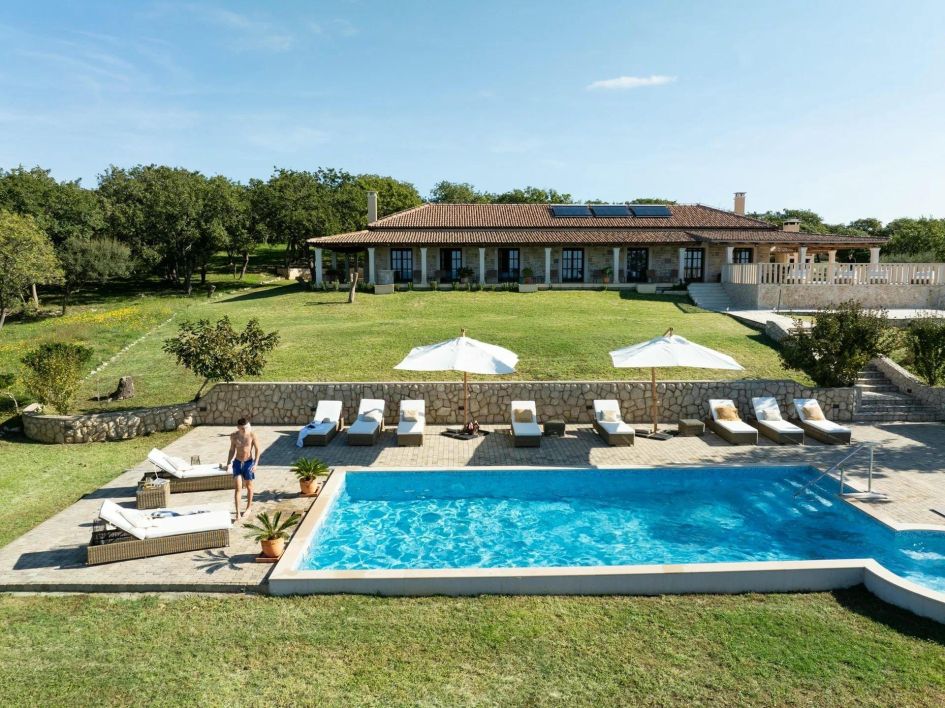 Villa Magran, Croatia Surrounded by a pine forest, A garden leads from the villa down towards a swimming pool level with poolside loungers.