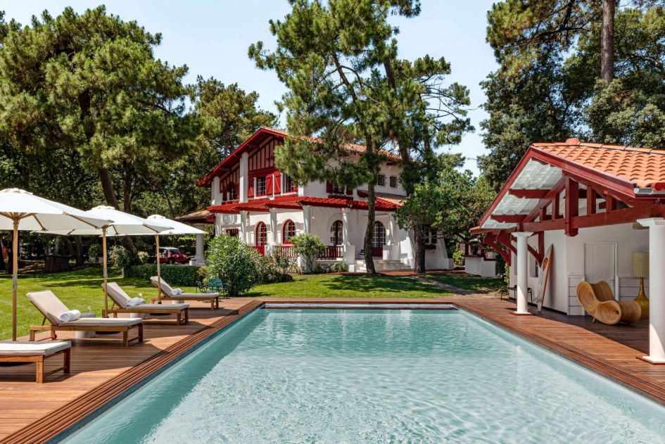 Les Bords du Lac, South-West France A serene garden landscape for moments of relaxation, poolside loungers and the main and side villas in full view.