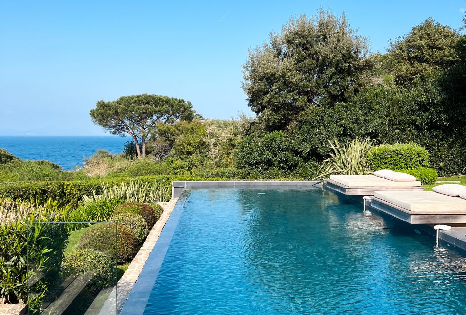 Luxury Villas in St Tropez The outdoor swimming pool, sea views and surrounding greenery seen from a luxury villa in St Tropez.
