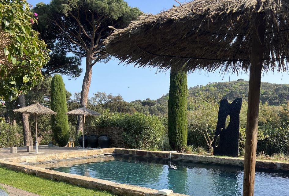 A Taste of St Tropez: Luxury Villa Holidays in St Tropez View from the terrace of a luxury villa in St Tropez, looking out to the swimming pool and parasols, surrounding by vegetation and greenery in the distance.