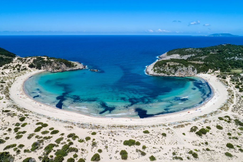 Voidokilia Beach, Peloponnese. Copyright - verve231 @ canva.com An aerial shot of Voidokilia Beach in the Peloponnese region of Greece. Its distinctive crescent shape makes it unmissable and many noticed this as being one of The Odyssey's filming locations.
